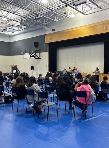 Students attending a presentation for healthcare in a gymnasium.