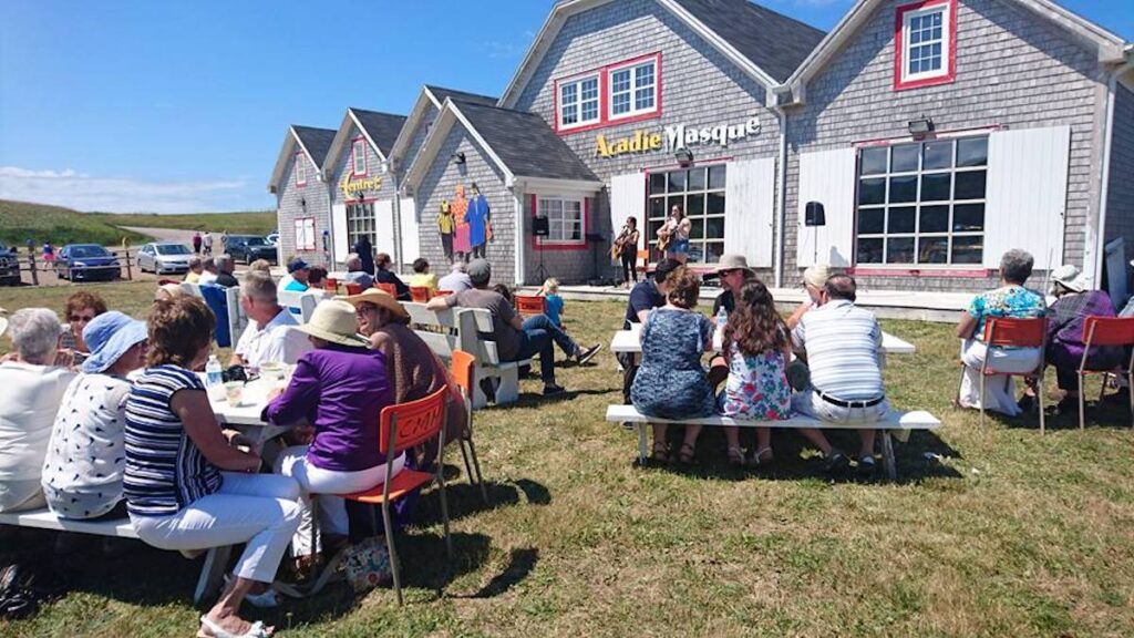 Exterior photo of Mi-Carême Centre with people packed around picnic tables.